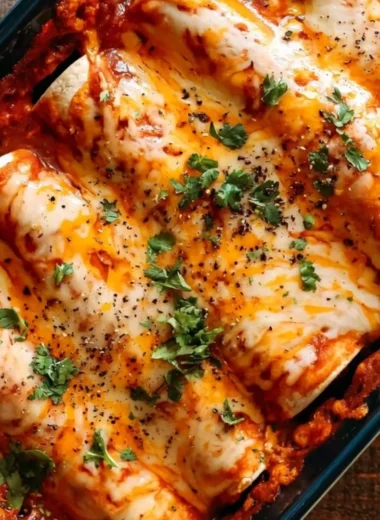 Delicious plate of easy bean and cheese enchiladas topped with cheese and fresh herbs.