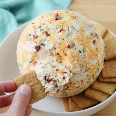 Delicious easy cheese ball appetizer served on a platter with crackers and veggies
